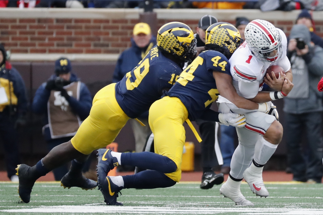 Nov 30, 2019; Ann Arbor, MI, USA; Ohio State Buckeyes quarterback Justin Fields (1) is tackled by Michigan Wolverines linebacker Cameron McGrone (44) and defensive lineman Kwity Paye (19) in the first half at Michigan Stadium. Mandatory Credit: Rick Osentoski-USA TODAY Sports