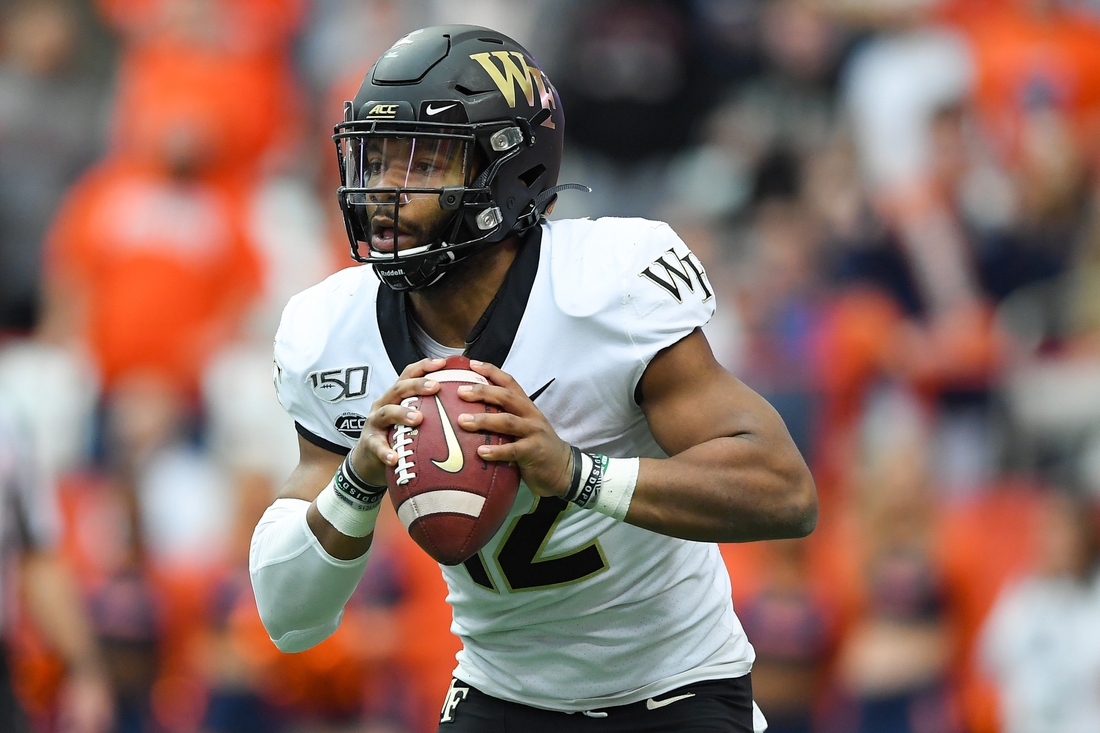 Nov 30, 2019; Syracuse, NY, USA; Wake Forest Demon Deacons quarterback Jamie Newman (12) runs with the ball against the Syracuse Orange during the first quarter at the Carrier Dome. Mandatory Credit: Rich Barnes-USA TODAY Sports