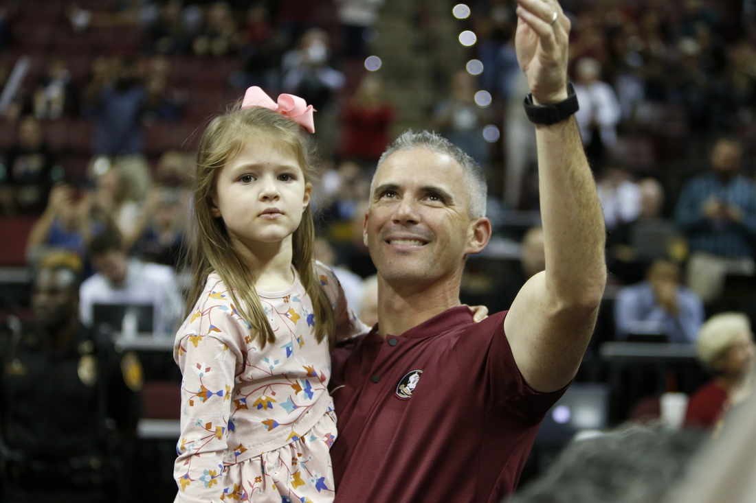 Dec 8, 2019; Tallahassee, FL, USA; The new Florida State Seminoles head football coach Mike Norvell waves to the crowd with his daughter Mila while being introduced during a stoppage in play against the Clemson Tigers at the Donald L. Tucker Center. Mandatory Credit: Glenn Beil-USA TODAY Sports