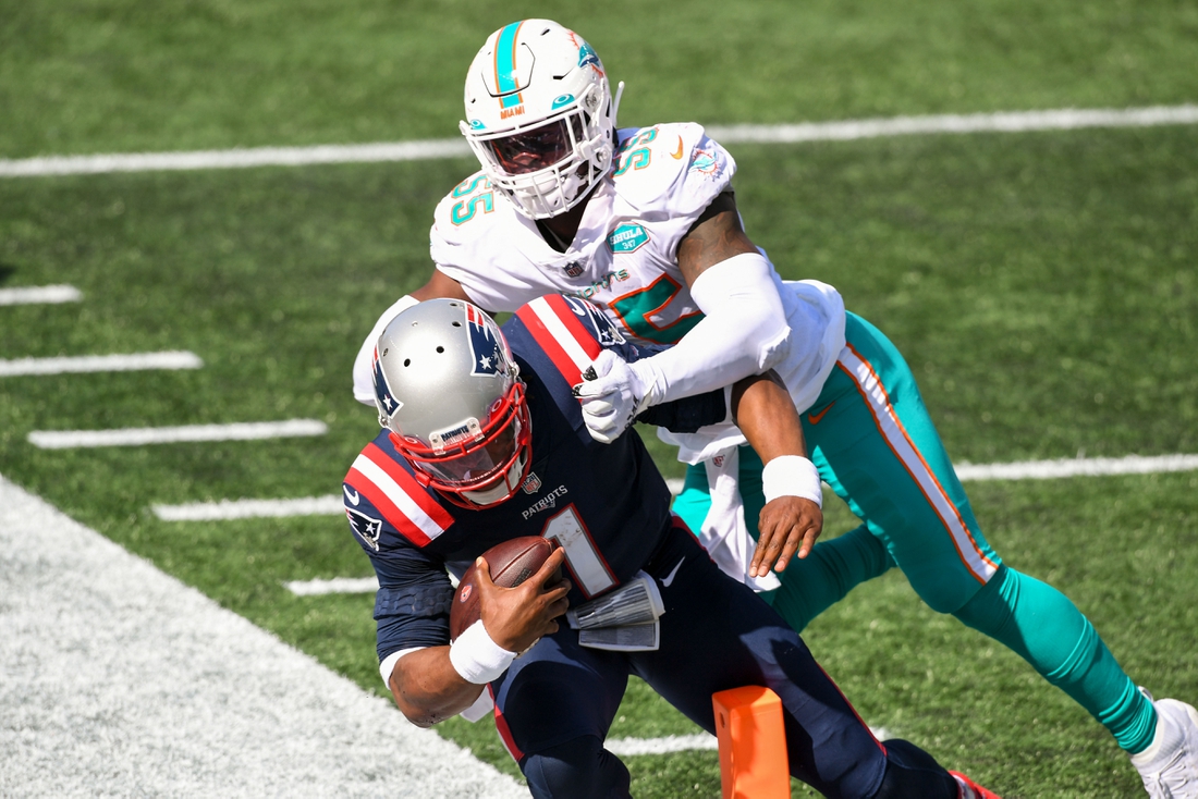 Sep 13, 2020; Foxborough, Massachusetts, USA; New England Patriots quarterback Cam Newton (1) runs for a touchdown in front of Miami Dolphins outside linebacker Jerome Baker (55) during the third quarter at Gillette Stadium. Mandatory Credit: Brian Fluharty-USA TODAY Sports