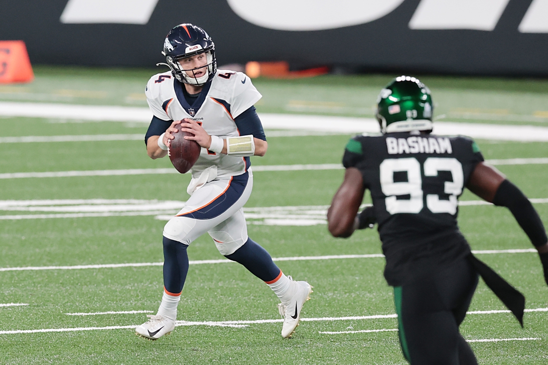 Oct 1, 2020; East Rutherford, New Jersey, USA;  Denver Broncos quarterback Brett Rypien (4) rolls out as New York Jets outside linebacker Tarell Basham (93) defends during the first half at MetLife Stadium. Mandatory Credit: Vincent Carchietta-USA TODAY Sports