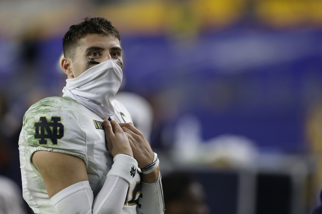 Oct 24, 2020; Pittsburgh, Pennsylvania, USA;  Notre Dame Fighting Irish quarterback Ian Book (12) looks on from the sidelines against the Pittsburgh Panthers during the fourth quarter at Heinz Field. The Fighting Irish won 45-3. Mandatory Credit: Charles LeClaire-USA TODAY Sports