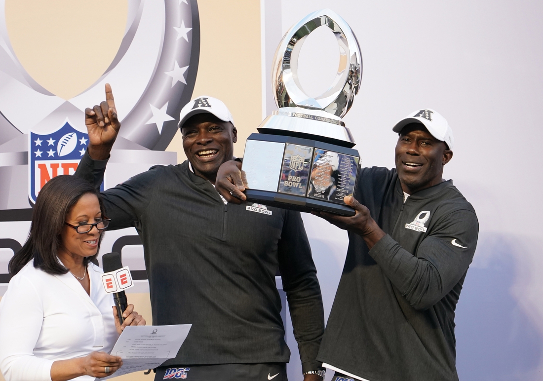 Jan 26, 2020; Orlando, Florida, USA; AFC legends coaches Bruce Smith (center) and Terrell Davis (right)  hoist the trophy during interview by ESPN sideline reporter Lisa Salters after the 2020 NFL Pro Bowl against the NFC at Camping World Stadium. The AFC defeated the NFC 38-33.  Mandatory Credit: Kirby Lee-USA TODAY Sports