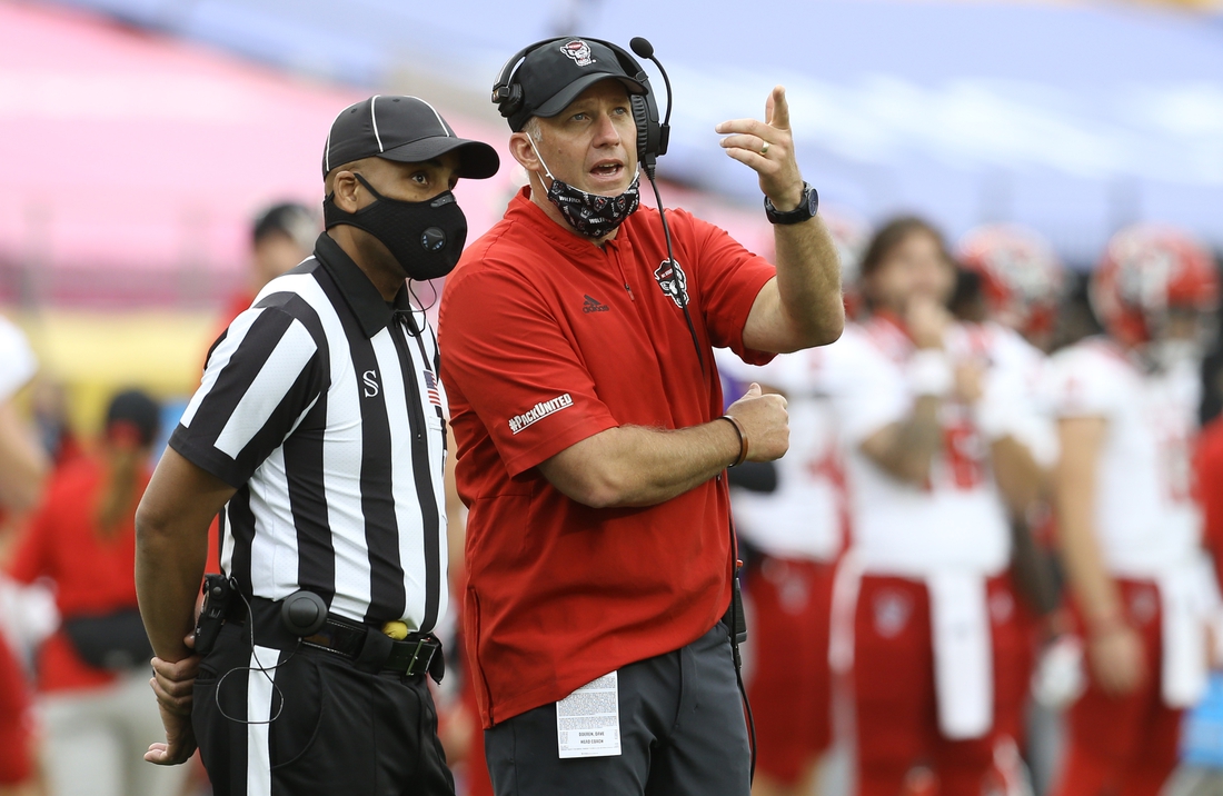 Oct 3, 2020; Pittsburgh, Pennsylvania, USA;  North Carolina State Wolfpack head coach Dave Doeren (right) makes a point to an official against the Pittsburgh Panthers during the third quarter at Heinz Field. The Wolfpack won 30-29. Mandatory Credit: Charles LeClaire-USA TODAY Sports