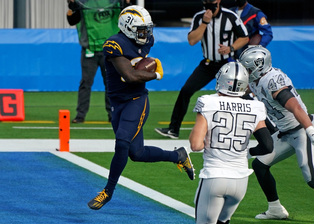 Nov 8, 2020; Inglewood, California, USA; Los Angeles Chargers running back Kalen Ballage (31) scores a touchdown as Las Vegas Raiders free safety Erik Harris (25) looks on during the first half at SoFi Stadium. Mandatory Credit: Kirby Lee-USA TODAY Sports