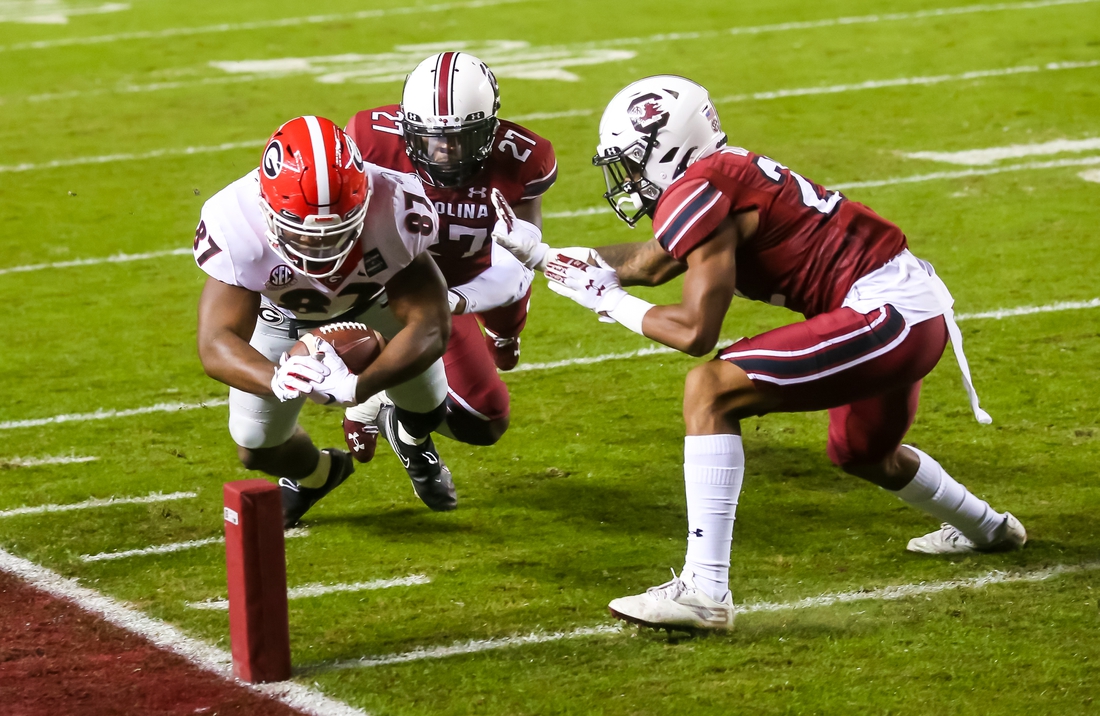 Nov 28, 2020; Columbia, South Carolina, USA; Georgia Bulldogs tight end Tre' McKitty (87) dives for the pylon for a touchdown as South Carolina Gamecocks defensive back John Dixon (22) and defensive back Shilo Sanders (21) defend during the first quarter at Williams-Brice Stadium. Mandatory Credit: Jeff Blake-USA TODAY