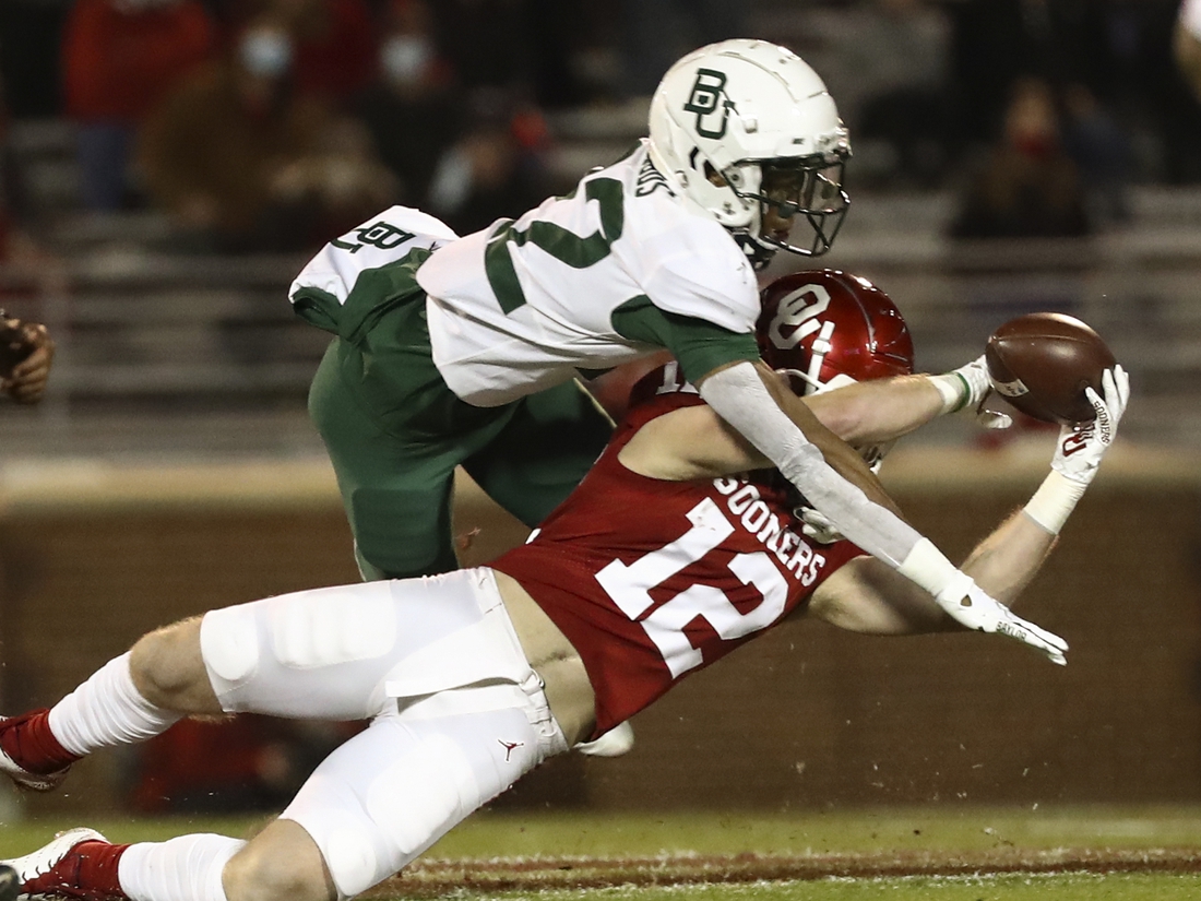 Dec 5, 2020; Norman, Oklahoma, USA; Oklahoma Sooners wide receiver Drake Stoops (12) makes a catch as Baylor Bears safety JT Woods (22) defends during the first half at Gaylord Family-Oklahoma Memorial Stadium. Mandatory Credit: Kevin Jairaj-USA TODAY Sports