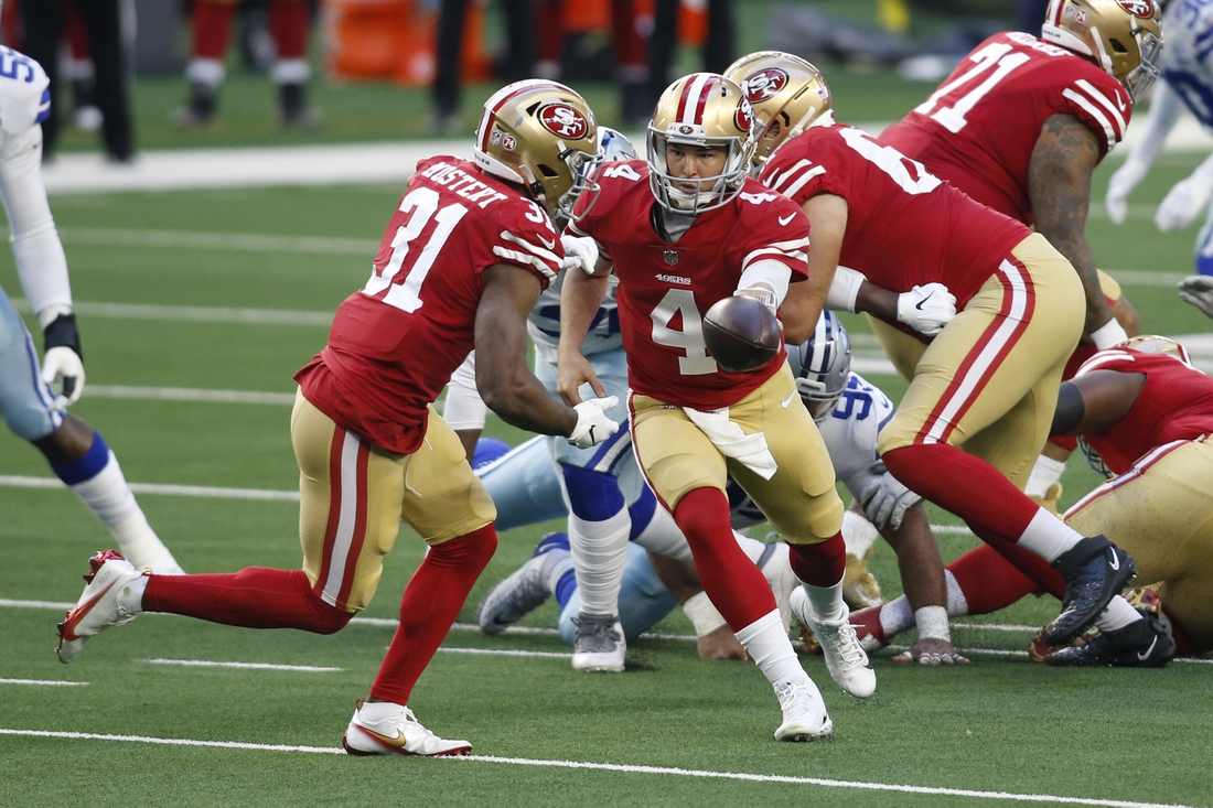 Dec 20, 2020; Arlington, Texas, USA; San Francisco 49ers quarterback Nick Mullens (4) hands off to running back Raheem Mostert (31) against the Dallas Cowboys in the first quarter at AT&T Stadium. Mandatory Credit: Tim Heitman-USA TODAY Sports