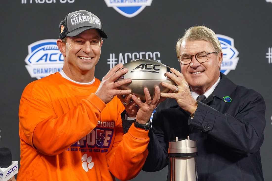 Dec 7, 2019; Charlotte, NC, USA; Clemson Tigers head coach Dabo Swinney receives the championship trophy from Commissioner John Swofford in the 2019 ACC Championship Game at Bank of America Stadium. Mandatory Credit: Jim Dedmon-USA TODAY Sports