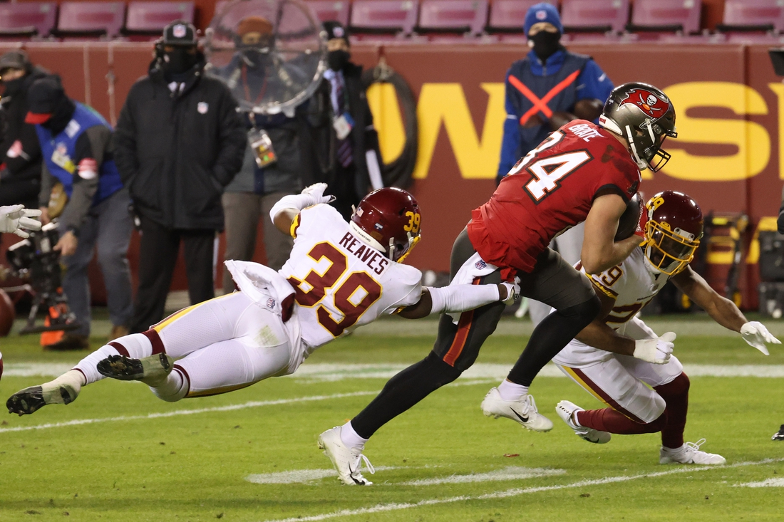 Jan 9, 2021; Landover, Maryland, USA; Tampa Bay Buccaneers tight end Cameron Brate (84) runs with the ball past Washington Football Team free safety Jeremy Reaves (39) in the second quarter at FedExField. Mandatory Credit: Geoff Burke-USA TODAY Sports