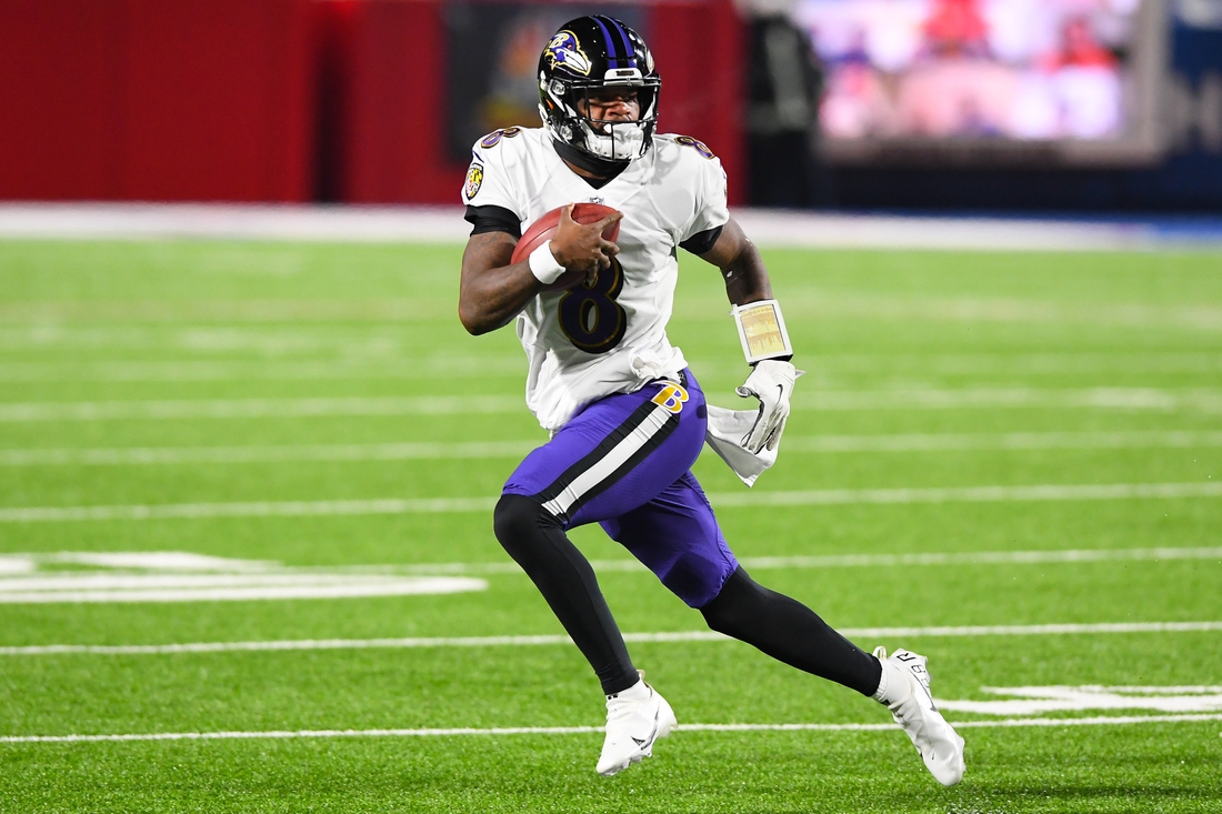 Jan 16, 2021; Orchard Park, New York, USA; Baltimore Ravens quarterback Lamar Jackson (8) runs with the ball against the Buffalo Bills during the first quarter of an AFC Divisional Round game at Bills Stadium. Mandatory Credit: Rich Barnes-USA TODAY Sports