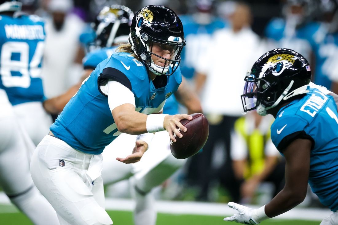 Aug 23, 2021; New Orleans, Louisiana, USA; Jacksonville Jaguars quarterback Trevor Lawrence (16) hands the ball off to running back Travis Etienne Jr. (1) against the New Orleans Saints during the first half at Caesars Superdome. Mandatory Credit: Stephen Lew-USA TODAY Sports