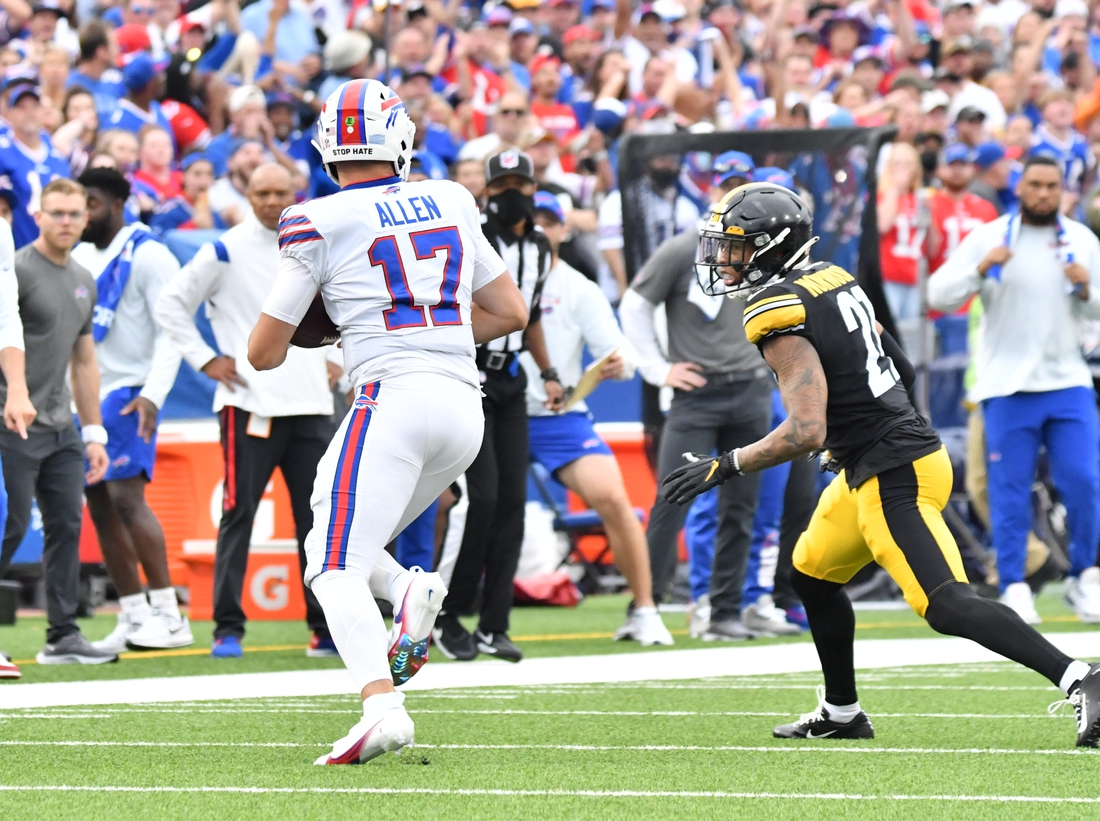 Sep 12, 2021; Orchard Park, New York, USA; Buffalo Bills quarterback Josh Allen (17) tries to outrun Pittsburgh Steelers cornerback Tre Norwood (21) in the first quarter of a game at Highmark Stadium. Mandatory Credit: Mark Konezny-USA TODAY Sports