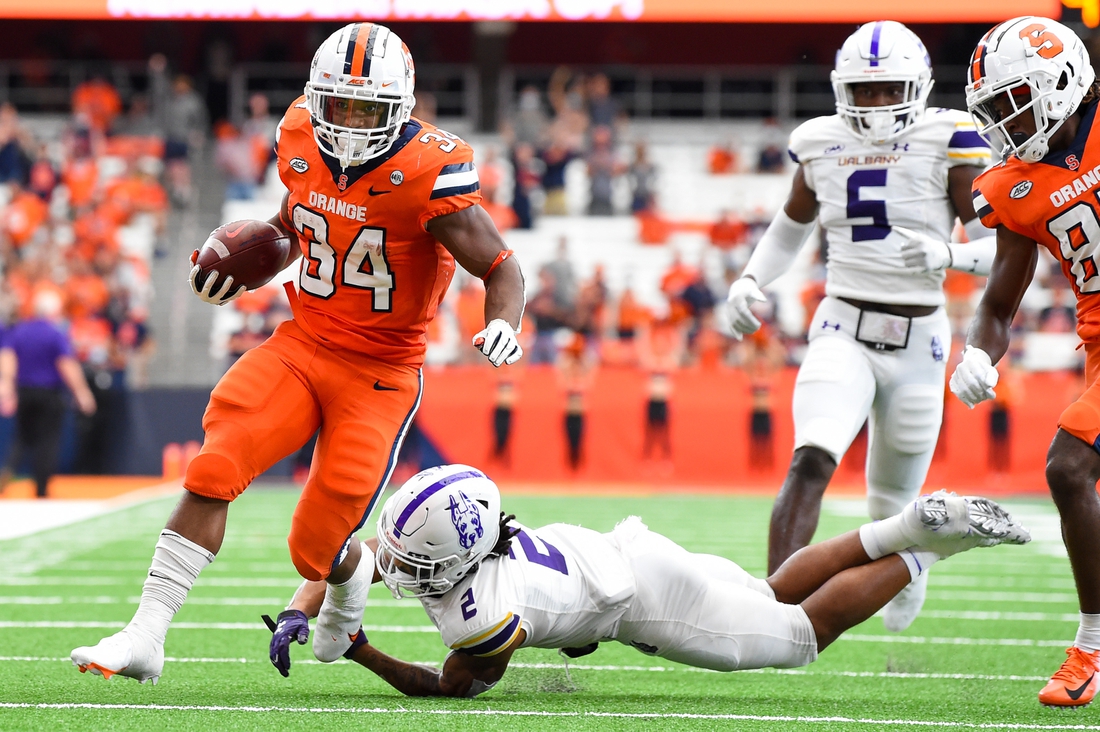 Sep 18, 2021; Syracuse, New York, USA; Syracuse Orange running back Sean Tucker (34) runs with the ball past the tackle attempt of Albany Great Danes defensive back Tyler Carswell (2) during the first half at the Carrier Dome. Mandatory Credit: Rich Barnes-USA TODAY Sports