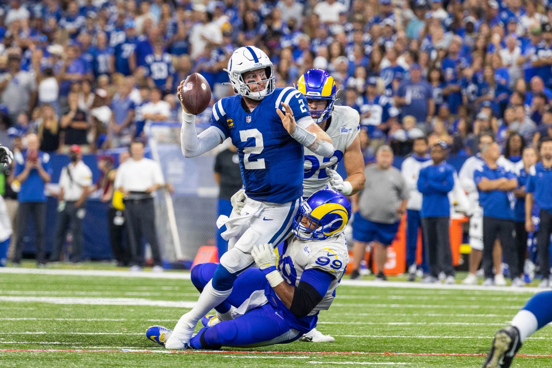 Sep 19, 2021; Indianapolis, Indiana, USA; Indianapolis Colts quarterback Carson Wentz (2) passes the ball while Los Angeles Rams defensive end Aaron Donald (99) defends in the second half at Lucas Oil Stadium. Mandatory Credit: Trevor Ruszkowski-USA TODAY Sports