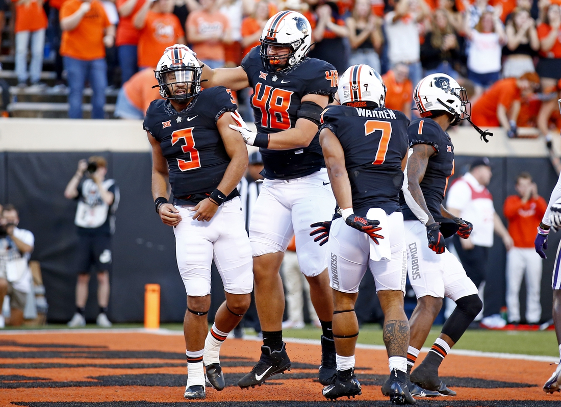 Sep 25, 2021; Stillwater, Oklahoma, USA; Oklahoma State's Spencer Sanders (3) celebrates with teammates after scoring a touchdown against the Kansas State Wildcats in the first quarter at Boone Pickens Stadium. Mandatory Credit: Sarah Phipps-USA TODAY Sports