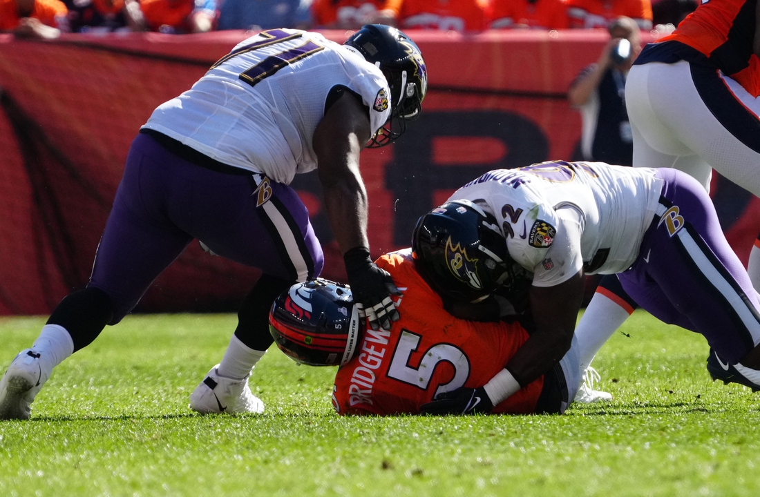 Oct 3, 2021; Denver, Colorado, USA; Baltimore Ravens defensive end Justin Madubuike (92) and defensive tackle Justin Ellis (71) tackle Denver Broncos quarterback Teddy Bridgewater (5) in the first quarter at Empower Field at Mile High. Mandatory Credit: Ron Chenoy-USA TODAY Sports