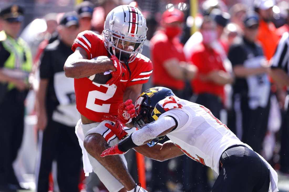 Oct 9, 2021; Columbus, Ohio, USA; Ohio State Buckeyes wide receiver Chris Olave (2) is tackled by Maryland Terrapins defensive back Tarheeb Still (12)during the first quarter at Ohio Stadium. Mandatory Credit: Joseph Maiorana-USA TODAY Sports