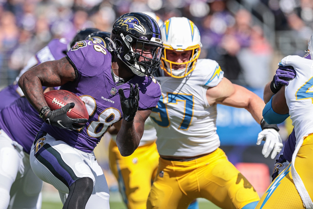 Oct 17, 2021; Baltimore, Maryland, USA; Baltimore Ravens running back Latavius Murray (28) carries the ball as Los Angeles Chargers defensive end Joey Bosa (97) defends during the first half at M&T Bank Stadium. Mandatory Credit: Vincent Carchietta-USA TODAY Sports