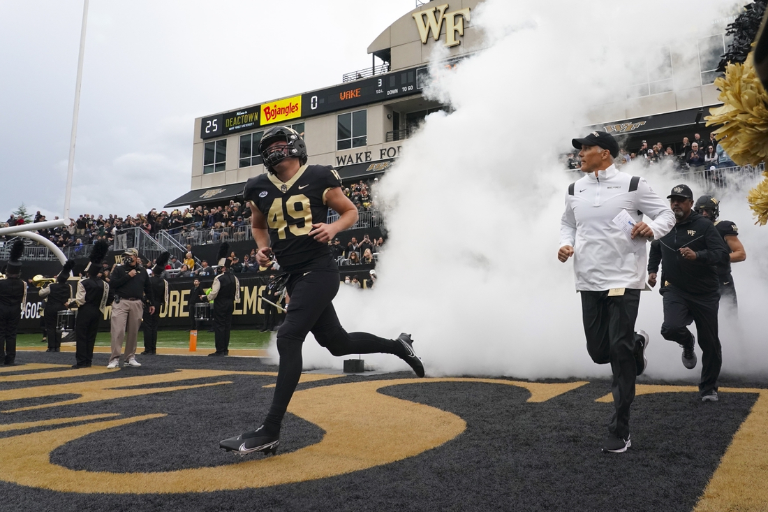 Oct 30, 2021; Winston-Salem, North Carolina, USA;  Wake Forest Demon Deacons head coach Dave Clawson and Wake Forest Demon Deacons defensive back Cody Cater (49) come out onto the field before the game against the Duke Blue Devils at Truist Field. Mandatory Credit: James Guillory-USA TODAY Sports