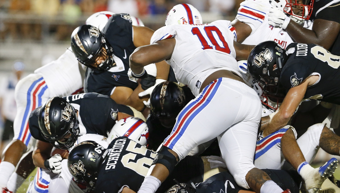 Oct 6, 2018; Orlando, FL, USA; UCF Knights defensive lineman Trysten Hill (top left) dives over the pile for a touchdown during the second half against the Southern Methodist Mustangs at Spectrum Stadium. Mandatory Credit: Reinhold Matay-USA TODAY Sports