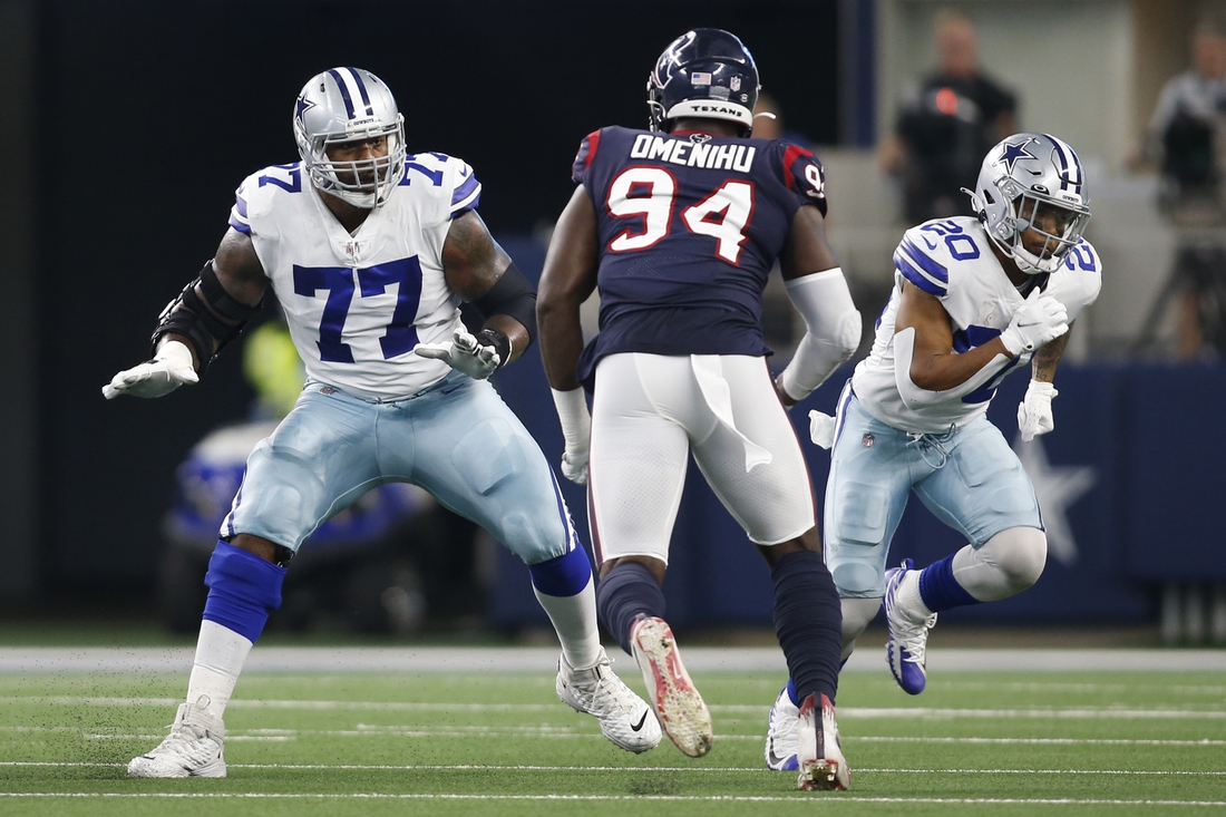 Aug 21, 2021; Arlington, Texas, USA; Dallas Cowboys offensive tackle Tyron Smith (77) blocks against Houston Texans defensive end Charles Omenihu (94) in the first quarter at AT&T Stadium. Mandatory Credit: Tim Heitman-USA TODAY Sports