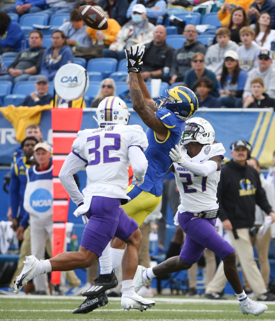 Delaware receiver Thyrick Pitts (1) pulls in a pass between James Madison's MJ Hampton (32) and Taurus Carroll in the second quarter at Delaware Stadium, Saturday, Oct. 23, 2021.

Ud V Jmu