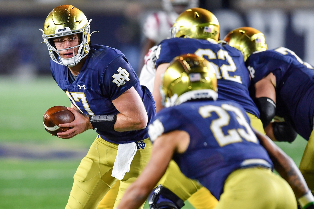 Oct 23, 2021; South Bend, Indiana, USA; Notre Dame Fighting Irish quarterback Jack Coan (17) looks to hand off to running back Kyren Williams (23) in the third quarter against the USC Trojans at Notre Dame Stadium. Mandatory Credit: Matt Cashore-USA TODAY Sports