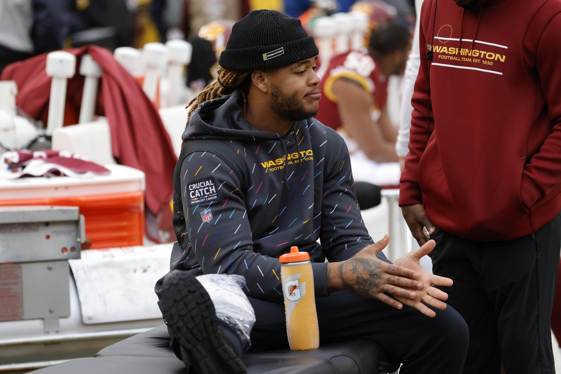 Nov 14, 2021; Landover, Maryland, USA; Washington Football Team defensive end Chase Young (99) sits on a table at the bench during the third quarter after being injured against the Tampa Bay Buccaneers at FedExField. Mandatory Credit: Geoff Burke-USA TODAY Sports