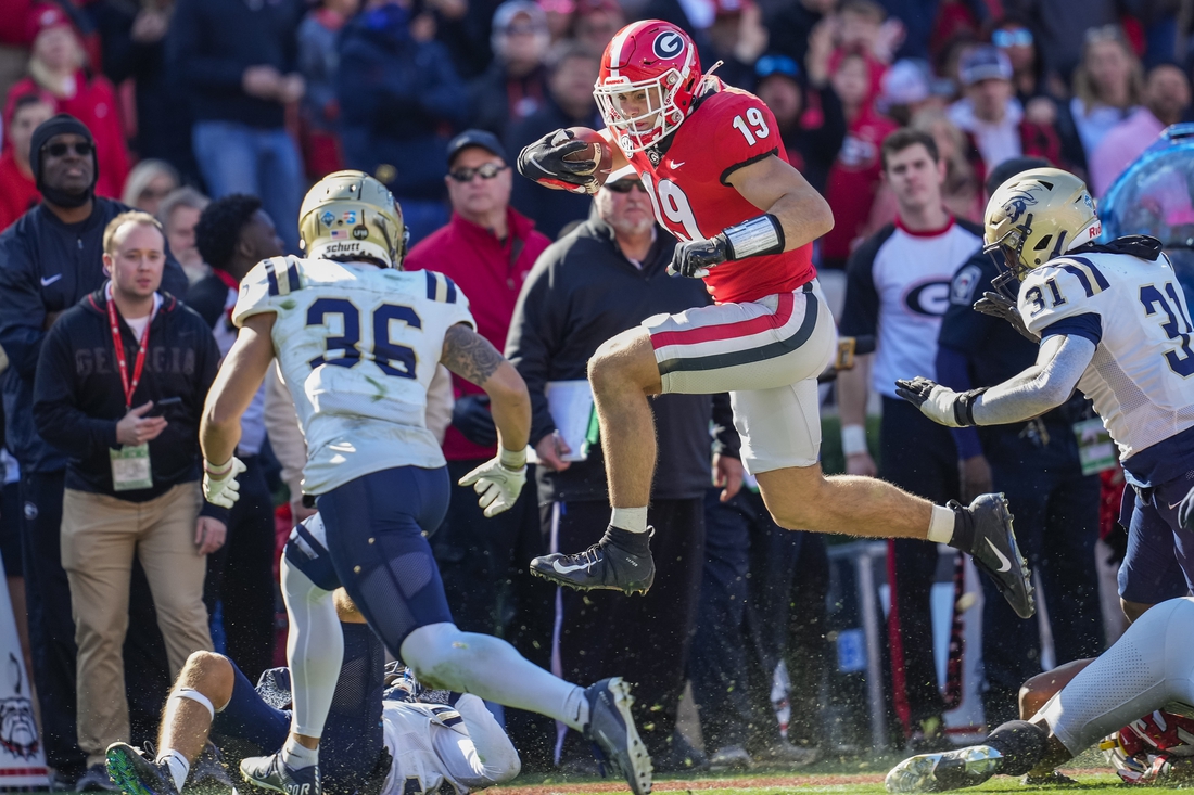 Nov 20, 2021; Athens, Georgia, USA; Georgia Bulldogs tight end Brock Bowers (19) jumps over Charleston Southern Buccaneers tacklers during the first quarter at Sanford Stadium. Mandatory Credit: Dale Zanine-USA TODAY Sports