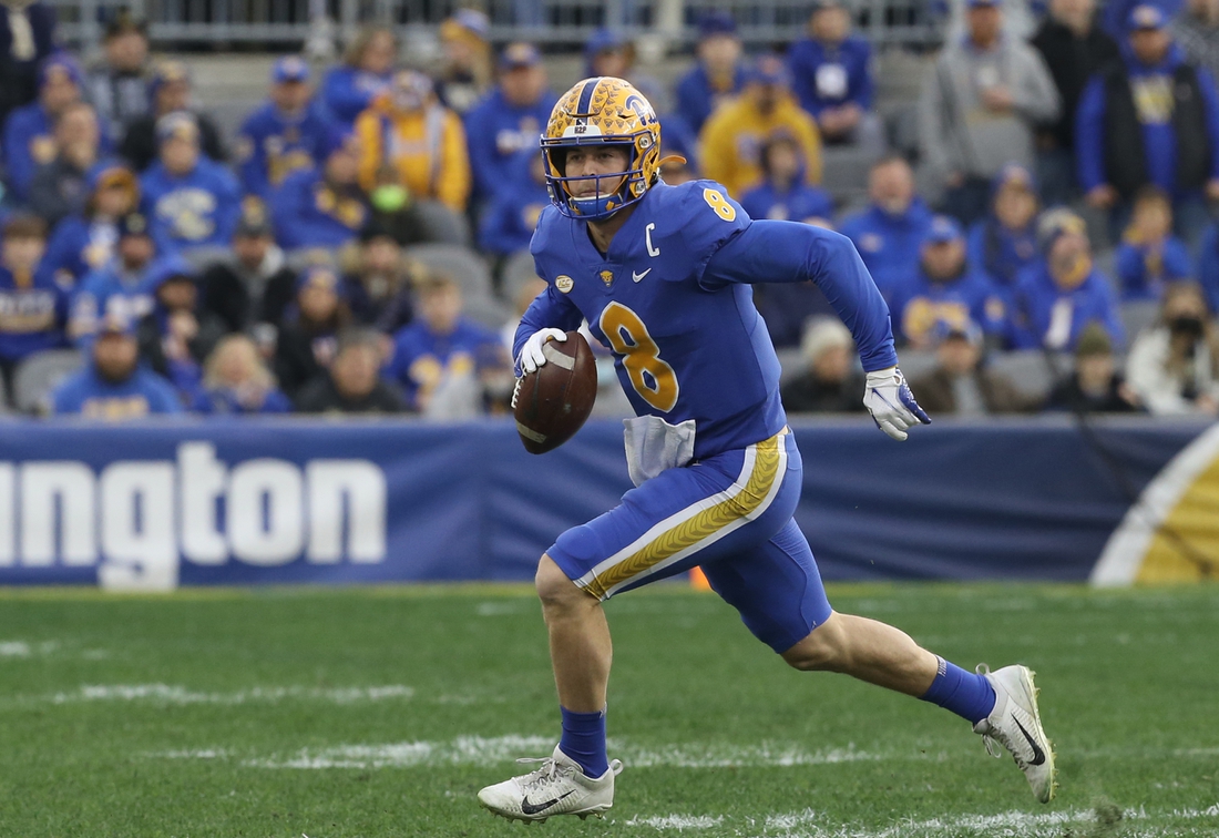 Nov 20, 2021; Pittsburgh, Pennsylvania, USA;  Pittsburgh Panthers quarterback Kenny Pickett (8) scrambles with the ball against the Virginia Cavaliers during the first quarter at Heinz Field. Mandatory Credit: Charles LeClaire-USA TODAY Sports