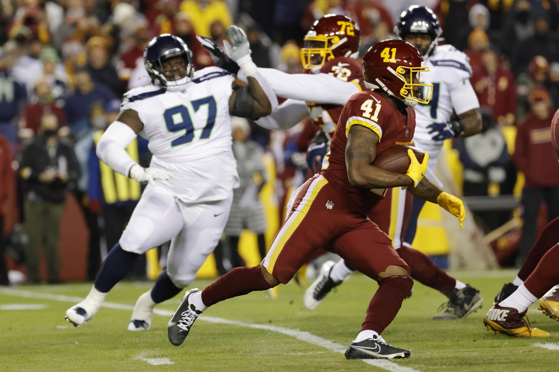 Nov 29, 2021; Landover, Maryland, USA; Washington Football Team running back J.D. McKissic (41) carries the ball past Seattle Seahawks defensive tackle Poona Ford (97) during the first quarter at FedExField. Mandatory Credit: Geoff Burke-USA TODAY Sports