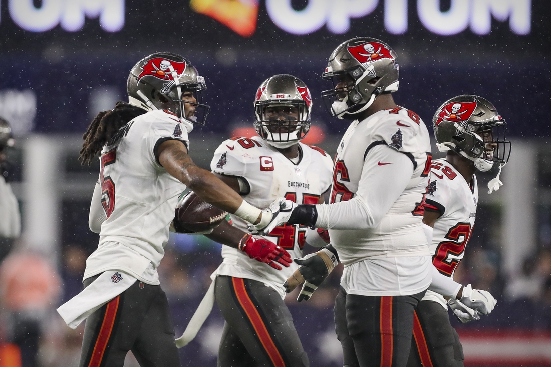 Oct 3, 2021; Foxboro, MA, USA; Tampa Bay Buccaneers cornerback Richard Sherman (5) and linebacker Devin White (45) and offensive tackle Donovan Smith (76) celebrate a turnover against the New England Patriots during the second half at Gillette Stadium.  Mandatory Credit: Paul Rutherford-USA TODAY Sports
