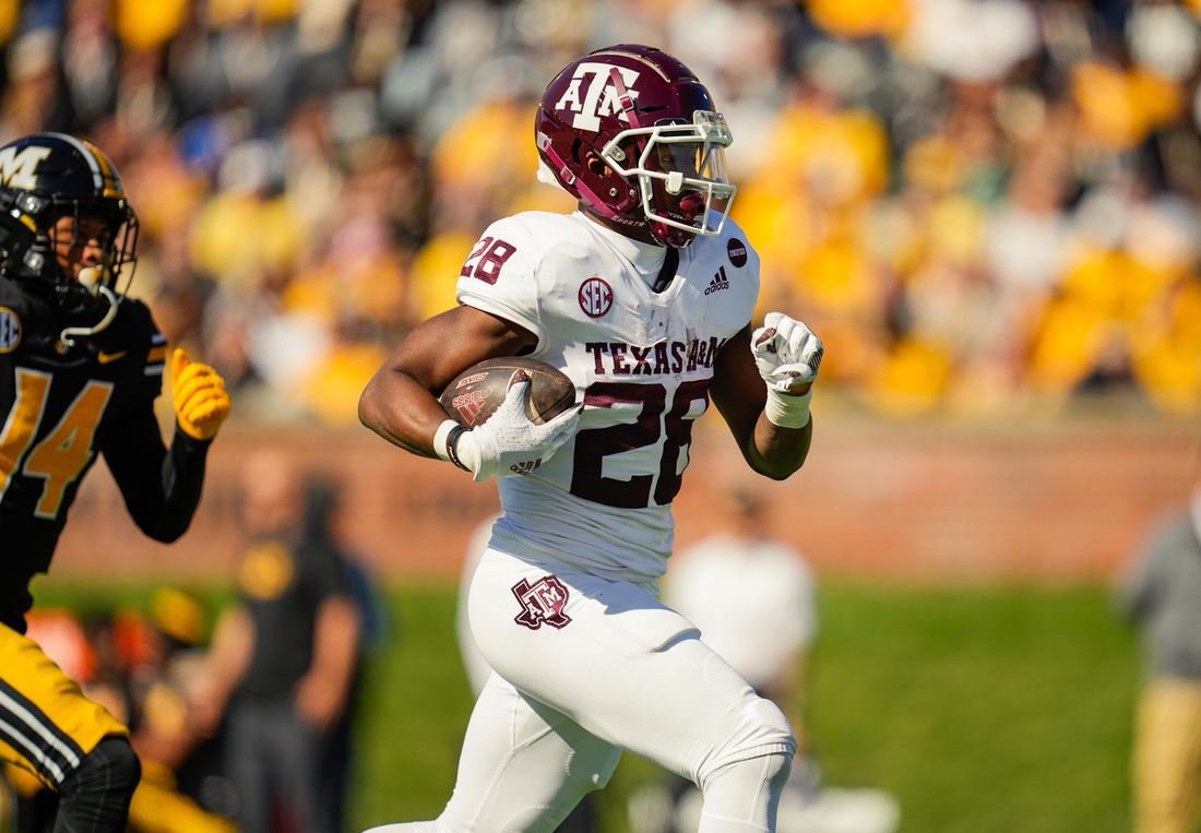 Oct 16, 2021; Columbia, Missouri, USA; Texas A&M Aggies running back Isaiah Spiller (28) runs for a touchdown against Missouri Tigers defensive back Kris Abrams-Draine (14) during the first half at Faurot Field at Memorial Stadium. Mandatory Credit: Jay Biggerstaff-USA TODAY Sports