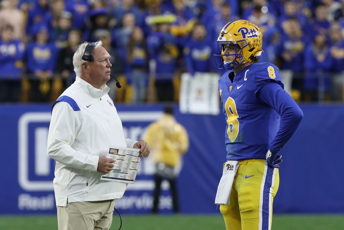 Oct 23, 2021; Pittsburgh, Pennsylvania, USA;  Pittsburgh Panthers offensive coordinator Mark Whipple (left) and quarterback Kenny Pickett (8) talk during a time-out against the Clemson Tigers in the fourth quarter at Heinz Field. Mandatory Credit: Charles LeClaire-USA TODAY Sports