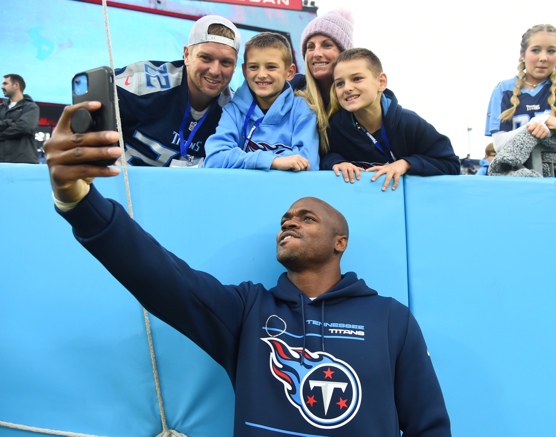 Nov 21, 2021; Nashville, Tennessee, USA; Tennessee Titans running back Adrian Peterson (8) takes a selfie with fans before the game against the Houston Texans at Nissan Stadium. Mandatory Credit: Christopher Hanewinckel-USA TODAY Sports