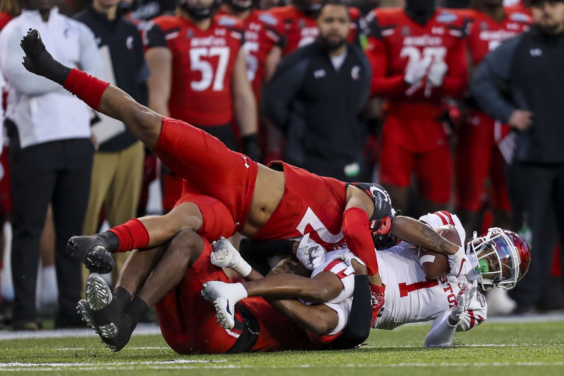 Dec 4, 2021; Cincinnati, Ohio, USA; Cincinnati Bearcats linebacker Deshawn Pace (20) and cornerback Arquon Bush (9) take down Houston Cougars wide receiver Nathaniel Dell (1) in the first half during the American Athletic Conference championship game at Nippert Stadium. Mandatory Credit: Katie Stratman-USA TODAY Sports