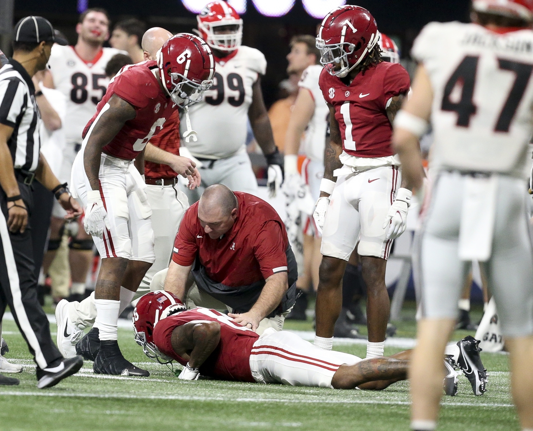 Dec 4, 2021; Atlanta, GA, USA; Trainers rush to the aide of Alabama wide receiver John Metchie III (8) after he was injured while playing against Georgia during the SEC championship game at Mercedes-Benz Stadium. Mandatory Credit: Gary Cosby Jr.-USA TODAY Sports