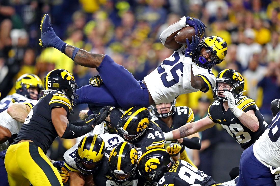 Dec 4, 2021; Indianapolis, IN, USA; Michigan Wolverines running back Hassan Haskins (25) leaps for a touchdown during the fourth quarter against the Iowa Hawkeyes in the Big Ten Conference championship game at Lucas Oil Stadium. Mandatory Credit: Mark J. Rebilas-USA TODAY Sports