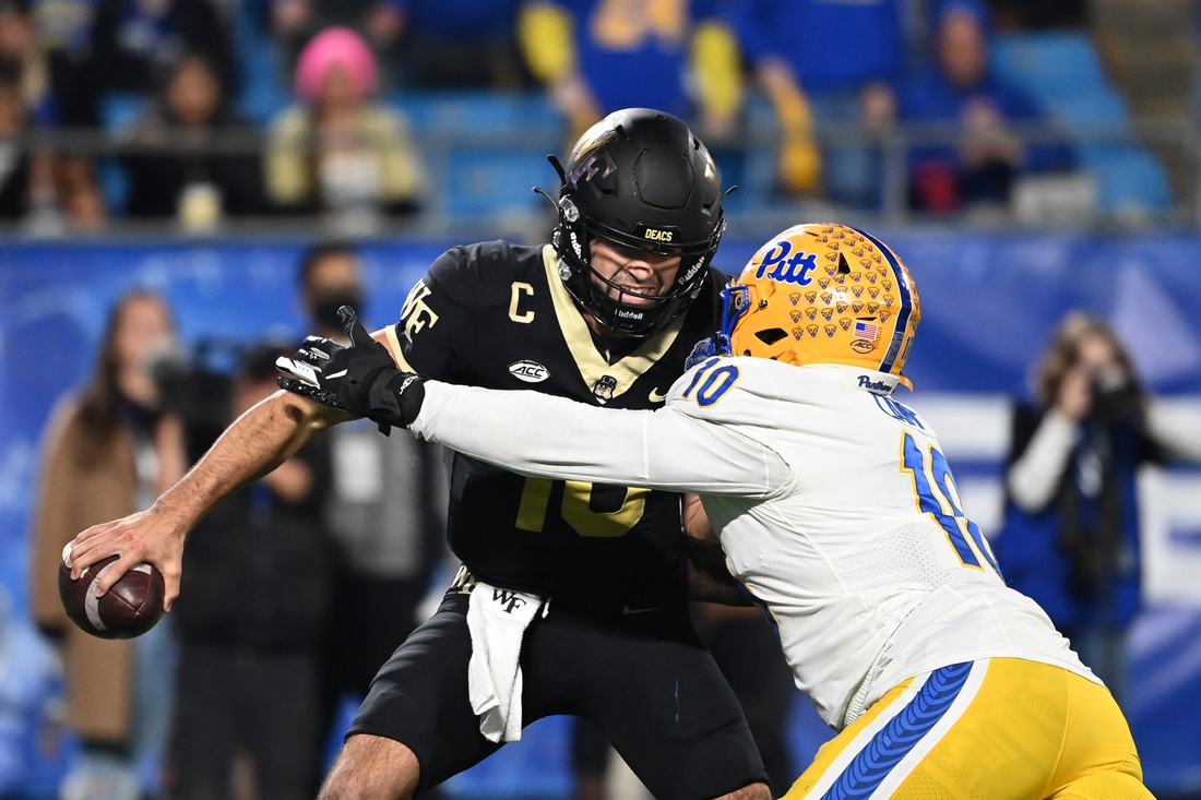 Dec 4, 2021; Charlotte, NC, USA; Wake Forest Demon Deacons quarterback Sam Hartman (10) is sacked by Pittsburgh Panthers defensive lineman Keyshon Camp (10) in the third quarter of the ACC championship game at Bank of America Stadium. Mandatory Credit: Bob Donnan-USA TODAY Sports