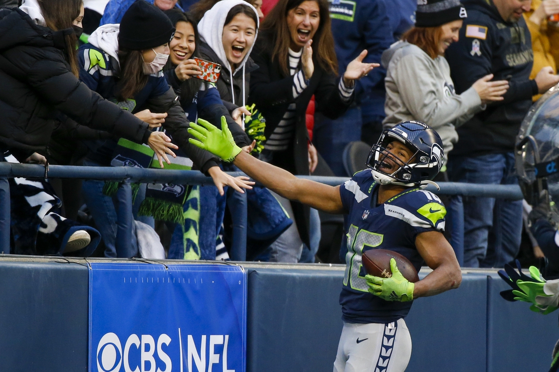 Dec 5, 2021; Seattle, Washington, USA; Seattle Seahawks wide receiver Tyler Lockett (16) celebrates with fans after catching a touchdown pass against the San Francisco 49ers during the third quarter at Lumen Field. Mandatory Credit: Joe Nicholson-USA TODAY Sports