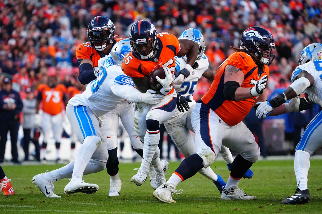 Dec 12, 2021; Denver, Colorado, USA; Denver Broncos running back Melvin Gordon III (25) carries for a touchdown past Detroit Lions linebacker Rashod Berry (43) in the third quarter at Empower Field at Mile High. Mandatory Credit: Ron Chenoy-USA TODAY Sports