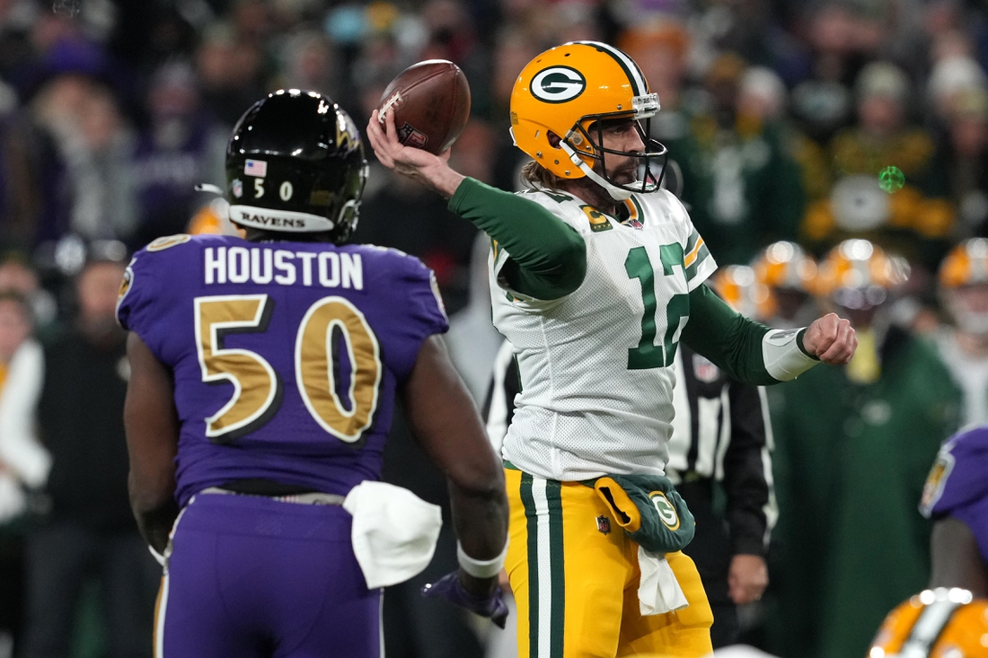 Dec 19, 2021; Baltimore, Maryland, USA; Green Bay Packers quarterback Aaron Rodgers (12) throws a pass while pressured by Baltimore Ravens linebacker Justin Houston (50) in the second quarter at M&T Bank Stadium. Mandatory Credit: Mitch Stringer-USA TODAY Sports