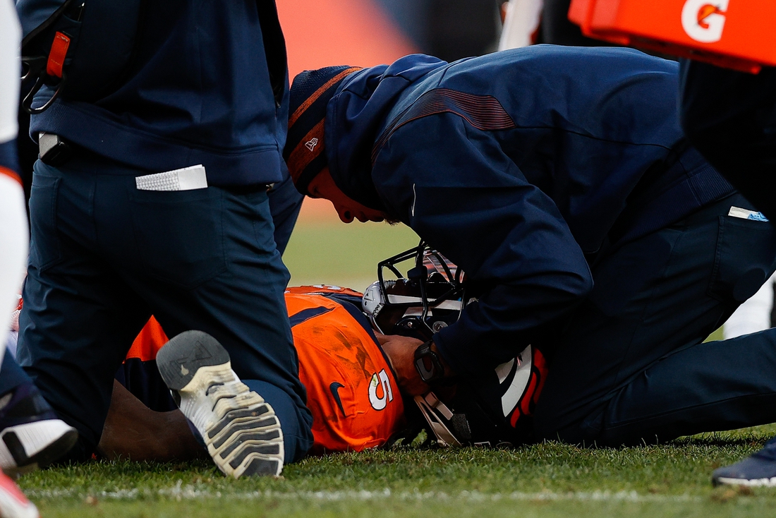 Dec 19, 2021; Denver, Colorado, USA; Denver Broncos quarterback Teddy Bridgewater (5) is tended to by personnel after a play in the third quarter against the Cincinnati Bengals at Empower Field at Mile High. Mandatory Credit: Isaiah J. Downing-USA TODAY Sports