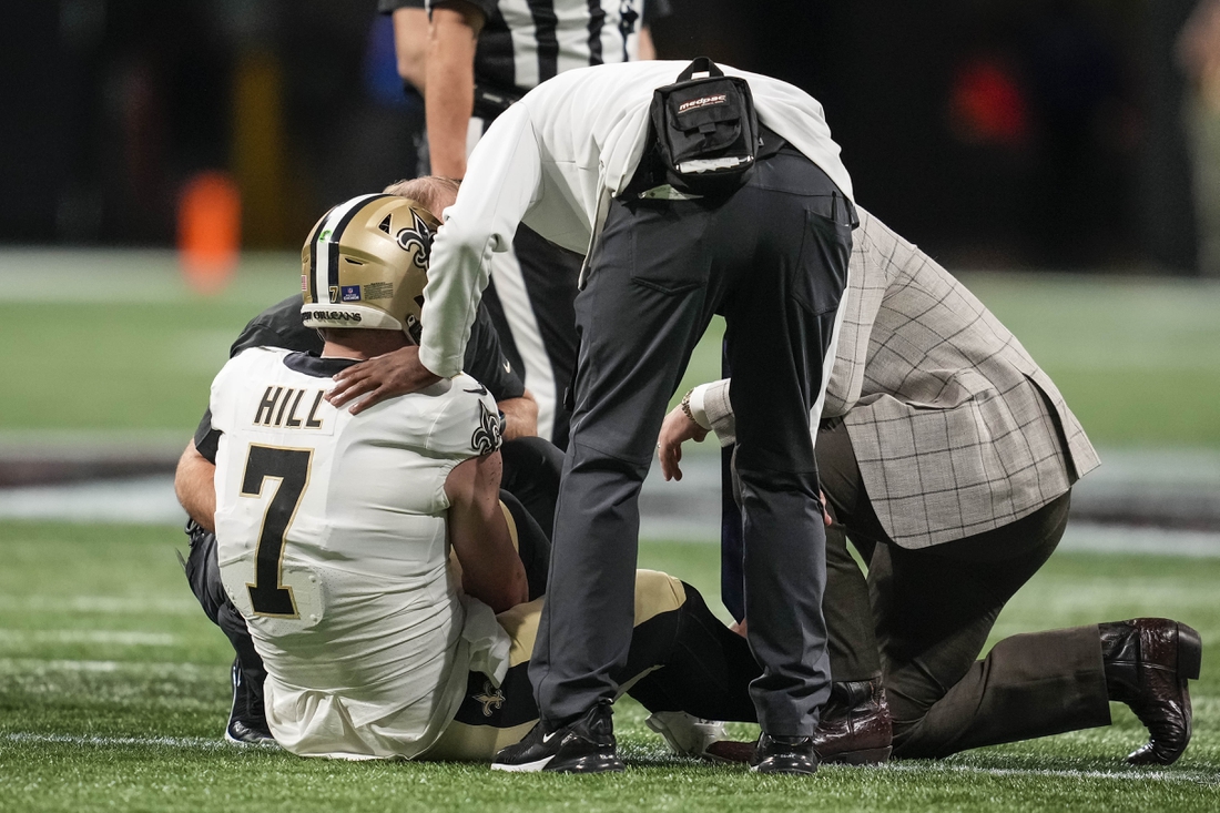 Jan 9, 2022; Atlanta, Georgia, USA; New Orleans Saints quarterback Taysom Hill (7) is checked after being injured running against the Atlanta Falcons during the first half at Mercedes-Benz Stadium. Mandatory Credit: Dale Zanine-USA TODAY Sports