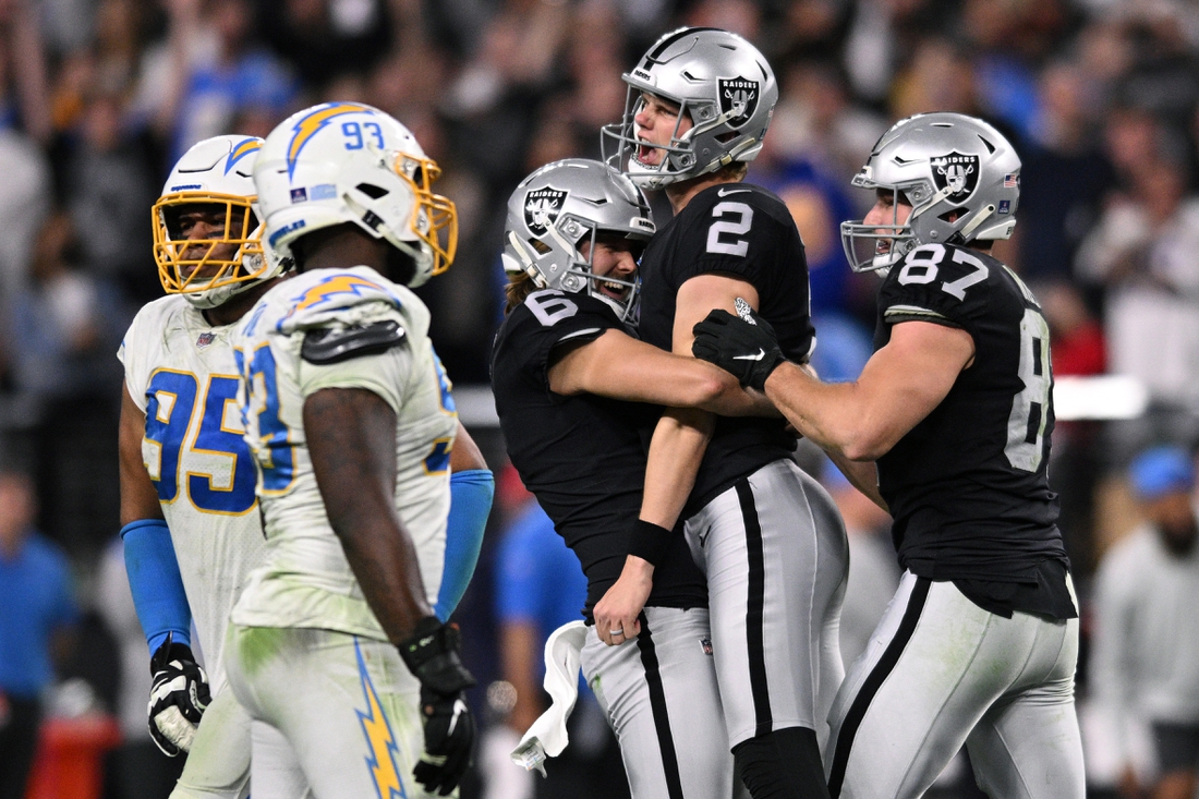 Jan 9, 2022; Paradise, Nevada, USA; Las Vegas Raiders kicker Daniel Carlson (2) celebrates with punter A.J. Cole (6) and tight end Foster Moreau (87) after kicking a game-winning field goal in overtime against the Los Angeles Chargers at Allegiant Stadium. Mandatory Credit: Orlando Ramirez-USA TODAY Sports