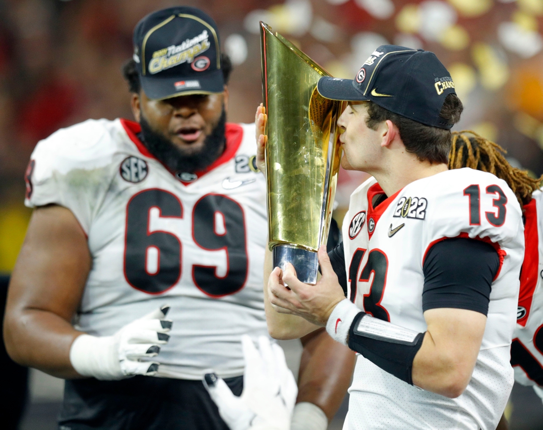 Georgia Bulldogs quarterback Stetson Bennett (13) kisses the trophy Tuesday, Jan. 11, 2022, after defeating Alabama in the College Football Playoff National Championship at Lucas Oil Stadium in Indianapolis.