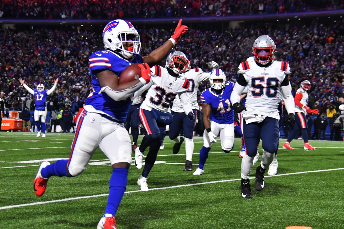 Jan 15, 2022; Orchard Park, New York, USA; Buffalo Bills running back Devin Singletary (26) runs for a touchdown during the second quarter of the AFC Wild Card playoff game against the New England Patriots at Highmark Stadium. Mandatory Credit: Mark Konezny-USA TODAY Sports