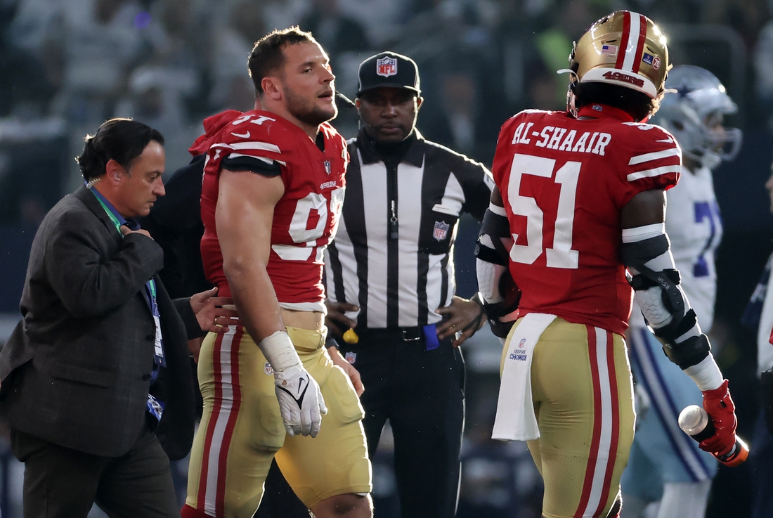 Jan 16, 2022; Arlington, Texas, USA; San Francisco 49ers defensive end Nick Bosa (97) walks off the field with team medical staff after an operant injury during the first half of the NFC Wild Card playoff football game against the San Francisco 49ers at AT&T Stadium. Mandatory Credit: Kevin Jairaj-USA TODAY Sports