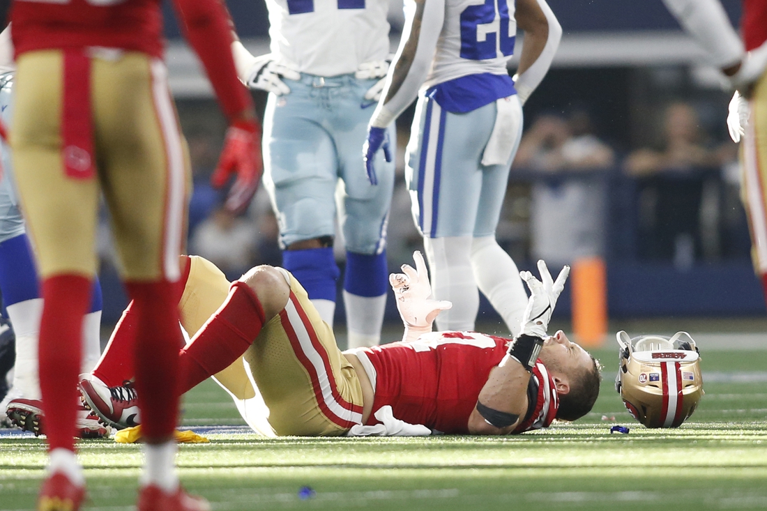 Jan 16, 2022; Arlington, Texas, USA; San Francisco 49ers defensive end Nick Bosa (97) lays on the field with an injury in the second quarter against the Dallas Cowboys in a NFC Wild Card playoff football game at AT&T Stadium. Mandatory Credit: Tim Heitman-USA TODAY Sports